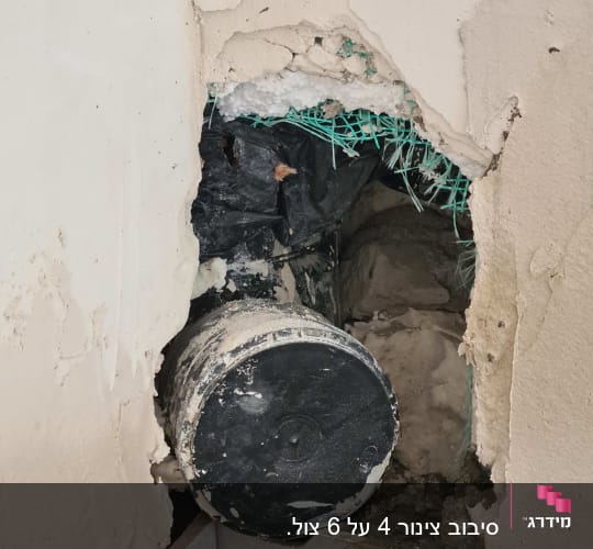 צינור מים חשוף בקיר עם חור בטיח